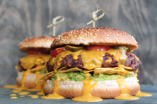 Tex-Mex-Burger mit Mexican-Cheezy-Sauce, Guacamole und Nachos